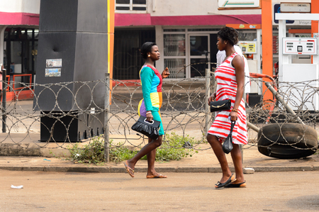 KUMASI, GHANA - Jan 16, 2017: Unidentified Ghanaian two women walk on the local market. People of Ghana suffer of poverty due to the bad economyのeditorial素材
