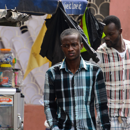 KUMASI, GHANA - Jan 16, 2017: Unidentified Ghanaian boy in plaid shirt looks away. People of Ghana suffer of poverty due to the bad economyのeditorial素材