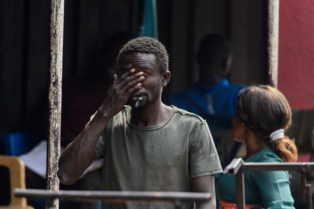 KUMASI, GHANA - Jan 16, 2017: Unidentified Ghanaian puts his hand on his face. People of Ghana suffer of poverty due to the bad economyのeditorial素材