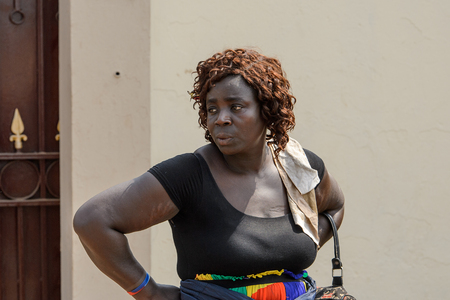 CENTRAL REGION, GHANA - Jan 17, 2017: Unidentified Ghanaian curly woman in black dress and colored skirt in local village. People of Ghana suffer of poverty due to the bad economyのeditorial素材