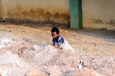 KUMASI, GHANA - Jan 16, 2017: Unidentified Ghanaian little boy plays on the ground. Children of Ghana suffer of poverty due to the bad economyのeditorial素材