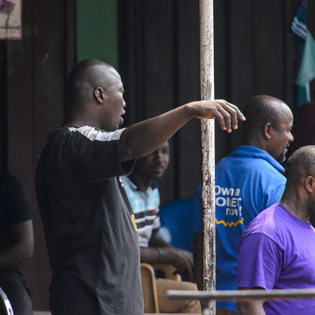 KUMASI, GHANA - Jan 16, 2017: Unidentified Ghanaian group of men stand near the house. People of Ghana suffer of poverty due to the bad economyのeditorial素材