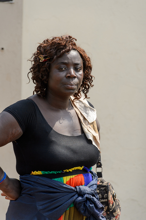 CENTRAL REGION, GHANA - Jan 17, 2017: Unidentified Ghanaian curly woman in black dress and colored skirt in local village. People of Ghana suffer of poverty due to the bad economyのeditorial素材