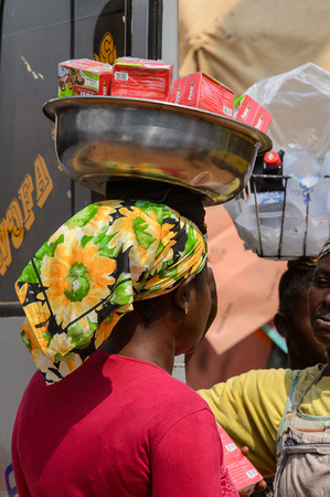 CENTRAL REGION, GHANA - Jan 17, 2017: Unidentified Ghanaian woman carries a basin on her head  in local village. People of Ghana suffer of poverty due to the bad economyのeditorial素材