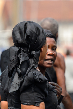 KUMASI, GHANA - Jan 16, 2017: Unidentified Ghanaian woman in black clothes and headscarf from behind. People of Ghana suffer of poverty due to the bad economyのeditorial素材