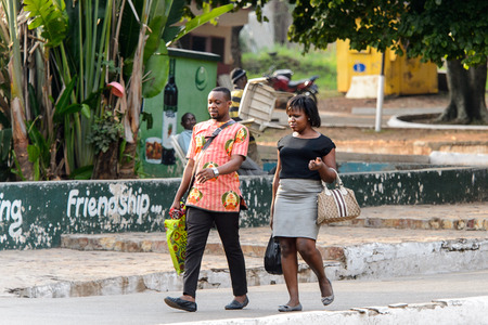 KUMASI, GHANA - Jan 16, 2017: Unidentified Ghanaian couple walk on the street. People of Ghana suffer of poverty due to the bad economyのeditorial素材
