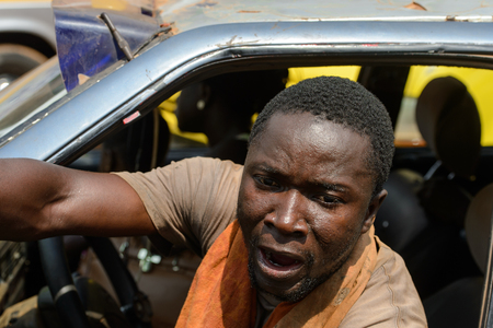 CENTRAL REGION, GHANA - Jan 17, 2017: Unidentified Ghanaian man drives a car in local village. People of Ghana suffer of poverty due to the bad economyのeditorial素材