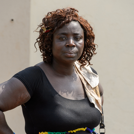 CENTRAL REGION, GHANA - Jan 17, 2017: Unidentified Ghanaian curly woman in black dress and colored skirt in local village. People of Ghana suffer of poverty due to the bad economyのeditorial素材