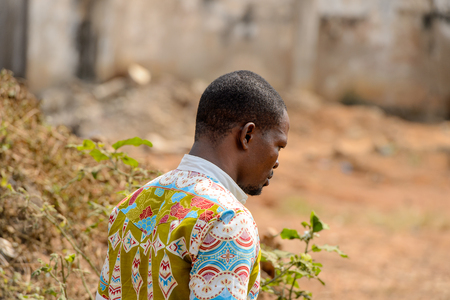 CENTRAL REGION, GHANA - Jan 17, 2017: Unidentified Ghanaian man from behind looks down in local village. People of Ghana suffer of poverty due to the bad economyのeditorial素材
