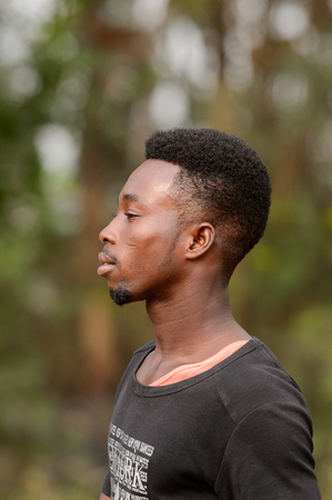 CENTRAL REGION, GHANA - Jan 17, 2017: Unidentified Ghanaian man in black shirt looks ahead in local village. People of Ghana suffer of poverty due to the bad economyのeditorial素材