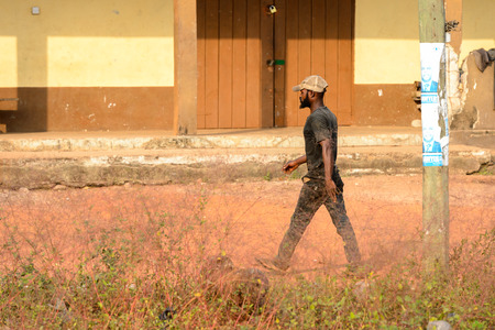 CENTRAL REGION, GHANA - Jan 17, 2017: Unidentified Ghanaian man walks along the street in local village. People of Ghana suffer of poverty due to the bad economyのeditorial素材