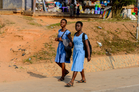 CENTRAL REGION, GHANA - Jan 17, 2017: Unidentified Ghanaian pupils in school uniform walk along the street in local village. Children of Ghana suffer of poverty due to the bad economyのeditorial素材