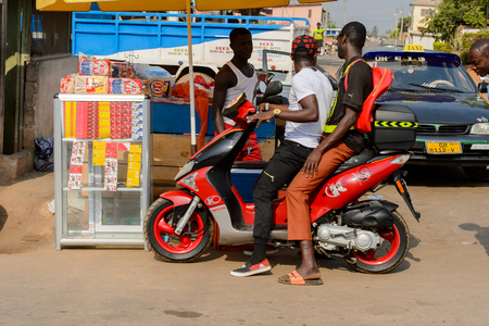 CENTRAL REGION, GHANA - Jan 17, 2017: Unidentified Ghanaian man drives a motorcycle in local village. People of Ghana suffer of poverty due to the bad economyのeditorial素材