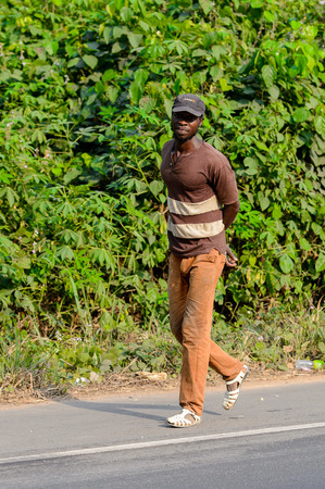 CENTRAL REGION, GHANA - Jan 17, 2017: Unidentified Ghanaian man walks along the road in local village. People of Ghana suffer of poverty due to the bad economyのeditorial素材