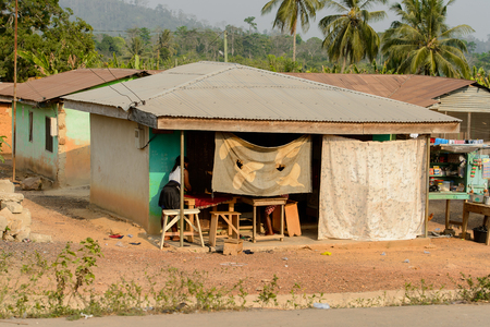CENTRAL REGION, GHANA - Jan 17, 2017: Unidentified Ghanaian woman stands near the house in local village. People of Ghana suffer of poverty due to the bad economyのeditorial素材