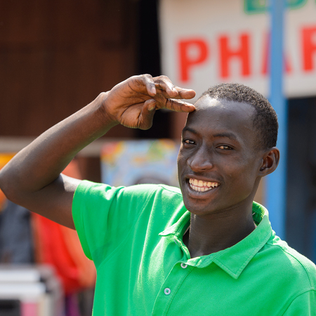 CENTRAL REGION, GHANA - Jan 17, 2017: Unidentified Ghanaian man in green shirt smiles in local village. People of Ghana suffer of poverty due to the bad economyのeditorial素材