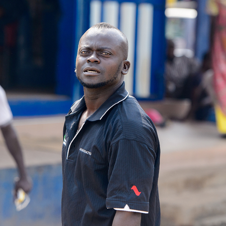 CENTRAL REGION, GHANA - Jan 17, 2017: Unidentified Ghanaian man in black shirt looks ahead in local village. People of Ghana suffer of poverty due to the bad economyのeditorial素材