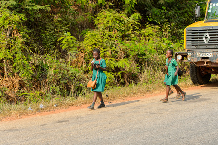 CENTRAL REGION, GHANA - Jan 17, 2017: Unidentified Ghanaian pupils walk along the street in local village. Children of Ghana suffer of poverty due to the bad economyのeditorial素材