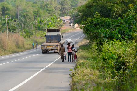 CENTRAL REGION, GHANA - Jan 17, 2017: Unidentified Ghanaian people walk along the road in local village. People of Ghana suffer of poverty due to the bad economyのeditorial素材