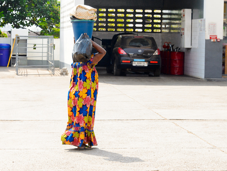 CENTRAL REGION, GHANA - Jan 17, 2017: Unidentified Ghanaian woman carries a bucket and plastic bag in local village. People of Ghana suffer of poverty due to the bad economyのeditorial素材