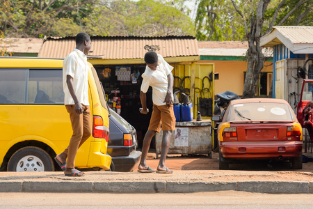CENTRAL REGION, GHANA - Jan 17, 2017: Unidentified Ghanaian boys in school uniform walk in local village. Children of Ghana suffer of poverty due to the bad economyのeditorial素材
