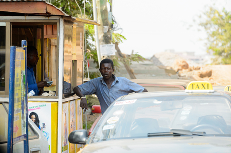 CENTRAL REGION, GHANA - Jan 17, 2017: Unidentified Ghanaian man stands behind the car in local village. People of Ghana suffer of poverty due to the bad economyのeditorial素材