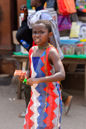 CENTRAL REGION, GHANA - Jan 17, 2017: Unidentified Ghanaian little girl holds some money and frowns in local village. Children of Ghana suffer of poverty due to the bad economyのeditorial素材
