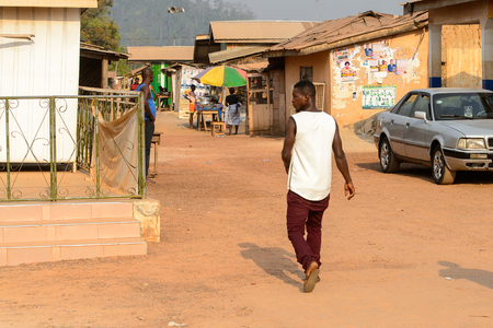 CENTRAL REGION, GHANA - Jan 17, 2017: Unidentified Ghanaian man walks along the street in local village. People of Ghana suffer of poverty due to the bad economyのeditorial素材