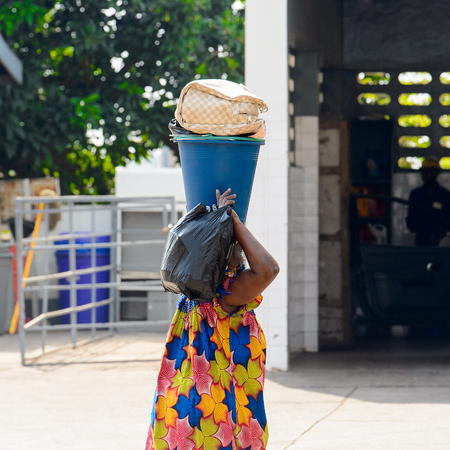 CENTRAL REGION, GHANA - Jan 17, 2017: Unidentified Ghanaian woman carries a bucket and plastic bag in local village. People of Ghana suffer of poverty due to the bad economyのeditorial素材