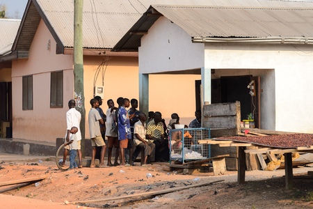 CENTRAL REGION, GHANA - Jan 17, 2017: Unidentified Ghanaian people gather near the building in local village. People of Ghana suffer of poverty due to the bad economyのeditorial素材