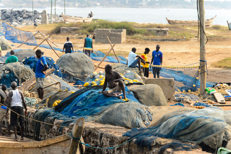 ELMINA, GHANA -JAN 18, 2017: Unidentified  Ghanaian people work in Elmina port near fishing nets. People of Ghana suffer of poverty due to the bad economyのeditorial素材