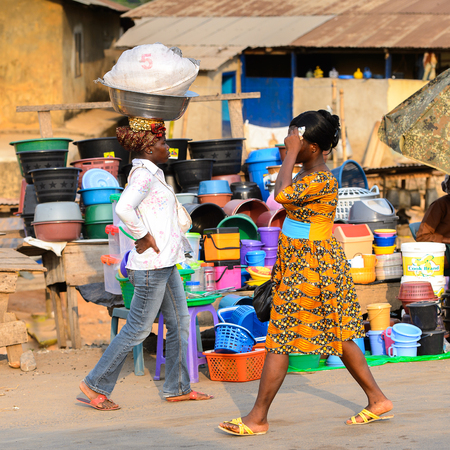 CENTRAL REGION, GHANA - Jan 17, 2017: Unidentified Ghanaian women walk along the market in local village. People of Ghana suffer of poverty due to the bad economyのeditorial素材