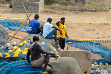 ELMINA, GHANA -JAN 18, 2017: Unidentified  Ghanaian man sits in the fishing net from behind in...
