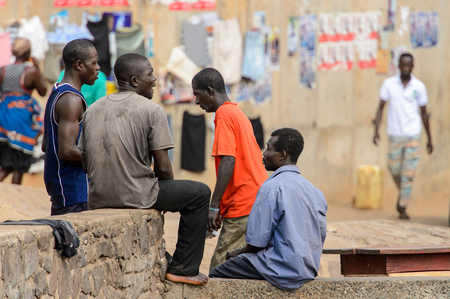 ELMINA, GHANA -JAN 18, 2017: Unidentified  Ghanaian people sit on the edge of the cliff in Elmina port. People of Ghana suffer of poverty due to the bad economyのeditorial素材