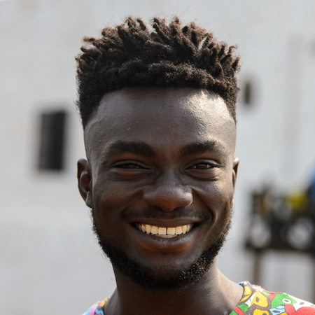 ELMINA, GHANA -JAN 18, 2017: Unidentified  Ghanaian man with dreads and beard in colored shirt smiles. People of Ghana suffer of poverty due to the bad economyのeditorial素材