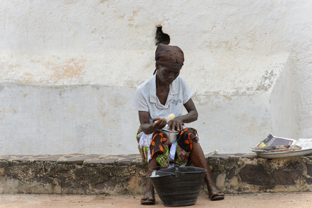 ELMINA, GHANA -JAN 18, 2017: Unidentified  Ghanaian old woman holds a spoon and a pan in Elmina. People of Ghana suffer of poverty due to the bad economyのeditorial素材