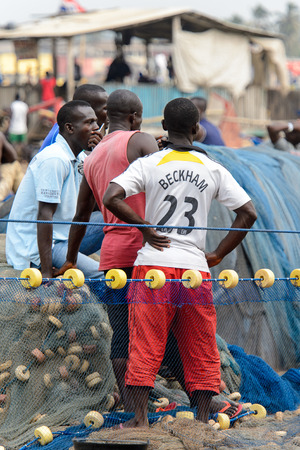 ELMINA, GHANA -JAN 18, 2017: Unidentified  Ghanaian people from behind in Elmina port. People of Ghana suffer of poverty due to the bad economyのeditorial素材