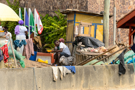 ELMINA, GHANA -JAN 18, 2017: Unidentified  Ghanaian man drinks water in Elmina port. People of Ghana suffer of poverty due to the bad economyのeditorial素材