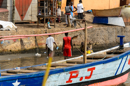 ELMINA, GHANA -JAN 18, 2017: Unidentified  Ghanaian walk from behind on the coast of Elmina. People of Ghana suffer of poverty due to the bad economyのeditorial素材