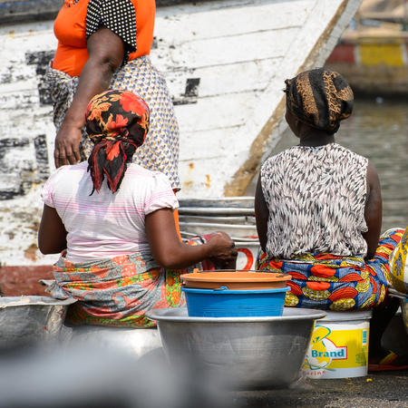 ELMINA, GHANA -JAN 18, 2017: Unidentified  Ghanaian women from behind in Elmina market. People of Ghana suffer of poverty due to the bad economyのeditorial素材