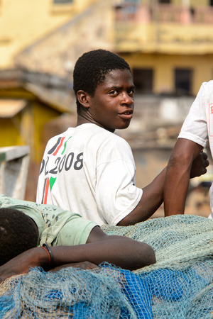 ELMINA, GHANA -JAN 18, 2017: Unidentified  Ghanaian boy in white shirt looks around on the coast of Elmina. People of Ghana suffer of poverty due to the bad economyのeditorial素材
