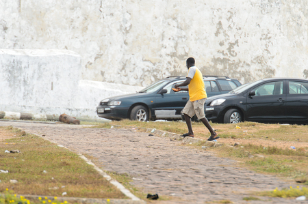 ELMINA, GHANA -JAN 18, 2017: Unidentified  Ghanaian man walks along the coast of Elmina. People of Ghana suffer of poverty due to the bad economyのeditorial素材