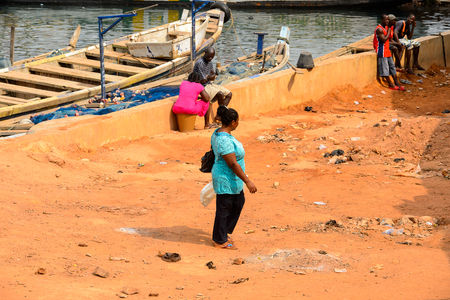 ELMINA, GHANA -JAN 18, 2017: Unidentified  Ghanaian woman walks along the coast of Elmina . People of Ghana suffer of poverty due to the bad economyのeditorial素材