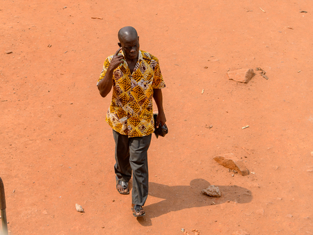 ELMINA, GHANA -JAN 18, 2017: Unidentified  Ghanaian man walks along the road in Elmina. People of Ghana suffer of poverty due to the bad economy.のeditorial素材