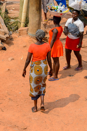 ELMINA, GHANA -JAN 18, 2017: Unidentified  Ghanaian woman in red shirt from behind in Elmina. People of Ghana suffer of poverty due to the bad economyのeditorial素材