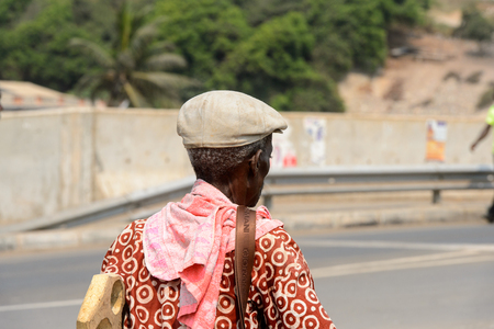 ELMINA, GHANA -JAN 18, 2017: Unidentified  Ghanaian man from behind walks along the road of Elmina. People of Ghana suffer of poverty due to the bad economyのeditorial素材