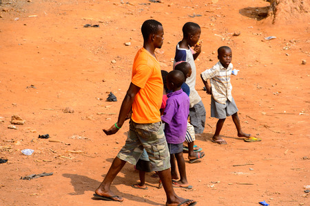 ELMINA, GHANA -JAN 18, 2017: Unidentified  Ghanaian children and grown-up walk on the street in Elmina. Children of Ghana suffer of poverty due to the bad economyのeditorial素材
