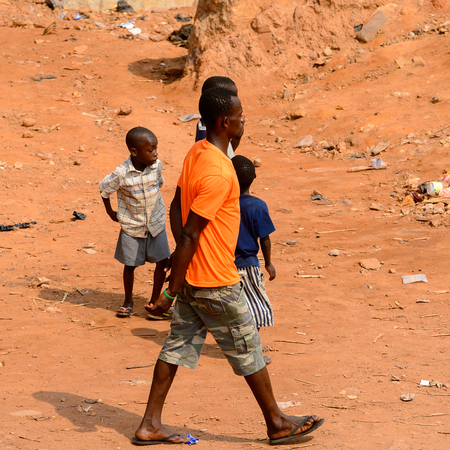 ELMINA, GHANA -JAN 18, 2017: Unidentified  Ghanaian children and grown-up walk on the street in Elmina. Children of Ghana suffer of poverty due to the bad economyのeditorial素材