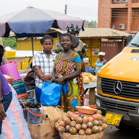CENTRAL REGION, GHANA - Jan 17, 2017: Unidentified Ghanaian women stand near the basin with pineapples in local village. People of Ghana suffer of poverty due to the bad economyのeditorial素材