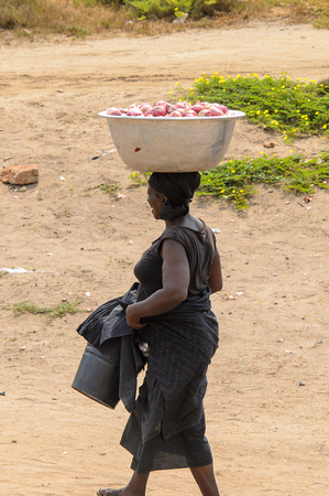 ELMINA, GHANA -JAN 18, 2017: Unidentified  Ghanaian woman walks along the market of Elmina . People of Ghana suffer of poverty due to the bad economyのeditorial素材